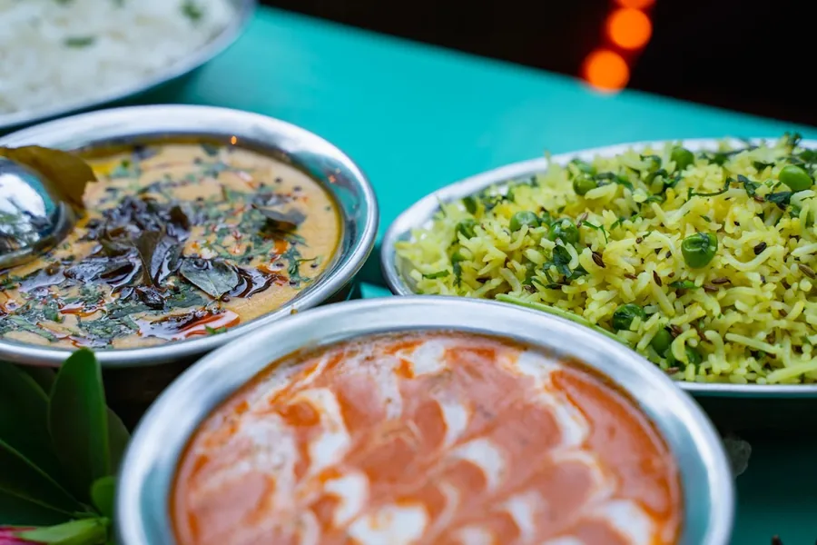 Vegetarian curries with rice on a teal table